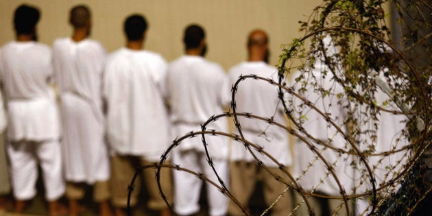 GUANTANAMO BAY, CUBA - OCTOBER 28: (EDITORS NOTE: Image has been reviewed by U.S. Military prior to transmission) Detainees stand during an early morning Islamic prayer at the U.S. military prison for 'enemy combatants' on October 28, 2009 in Guantanamo Bay, Cuba. Although U.S. President Barack Obama pledged in his first executive order last January to close the infamous prison within a year's time, the government has been struggling to try the accused terrorists and to transfer them out ahead of the deadline. Military officials at the prison point to improved living standards and state of the art medical treatment available to detainees, but the facility's international reputation remains tied to the 'enhanced interrogation techniques' such as waterboarding employed under the Bush administration. (Photo by John Moore/Getty Images)