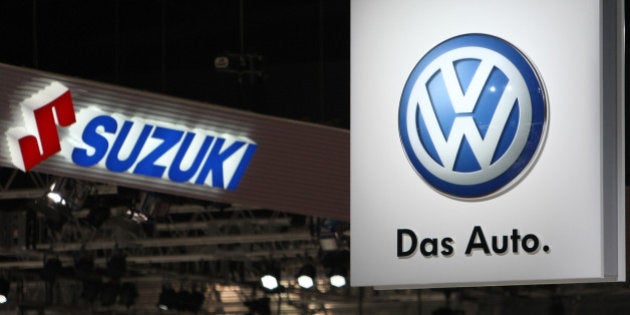 Suzuki Motor Corp., left, and Volkswagen AG (VW) logos are displayed at the Tokyo Motor Show 2011 in Tokyo, Japan, on Wednesday, Nov. 30, 2011. Japanese automakers compete for a dwindling number of local buyers at the show as the domestic market fails to provide a haven from a strong yen that's eroding profits from overseas sales. Photographer: Tomohiro Ohsumi/Bloomberg via Getty Images