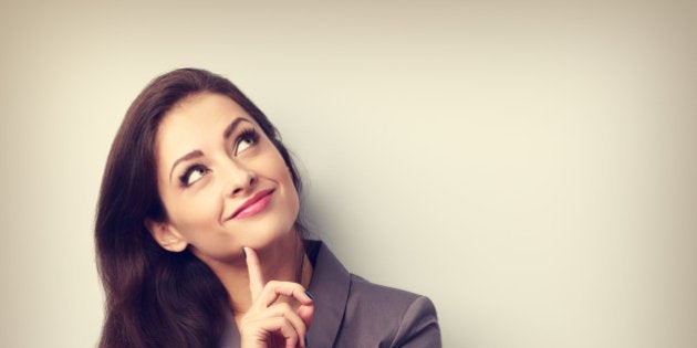 Beautiful young business woman thinking and looking up with finger under the face. Toned closeup portrait