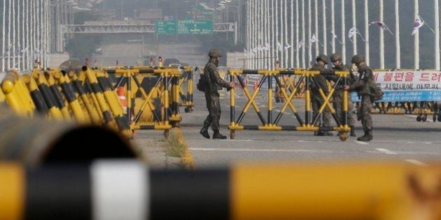 South Korean army soldiers adjust a barricade set up on Unification Bridge, which leads to the demilitarized zone, near the border village of Panmunjom in Paju, South Korea, Saturday, Aug. 22, 2015. North Korean leader Kim Jong Un on Friday declared his front-line troops in a