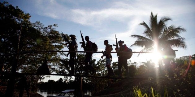 In this Aug. 12, 2016 photo, rebels of the 48th Front of the Revolutionary Armed Forces of Colombia walk on a makeshift footbridge in the southern jungles of Putumayo, Colombia. With the peace accords about to signed between the FARC and the governemt, gone are the days when they had to change camp every few days for fear of being stunned in their sleep by bombs falling from the skies. (AP Photo/Fernando Vergara)