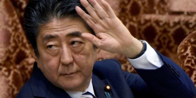 Japanese Prime Minister Shinzo Abe raises his hand before answering questions during the budget committee of the upper house of parliament in Tokyo on June 16, 2017.Abe was under mounting pressure over allegations that he used his influence to help a friend in a business deal after two official reports appeared to back up the claims. / AFP PHOTO / Toru YAMANAKA (Photo credit should read TORU YAMANAKA/AFP/Getty Images)