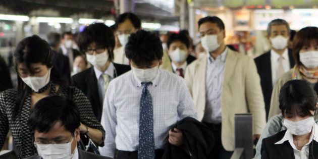 JAPAN - MAY 22: Commuters wear masks at the Osaka Station in Osaka City, Japan, on Friday, May 22, 2009. Swine flu spread to more people in Japan as the government moderated its response to the outbreak, and claimed another life in the U.S. in a scourge that's reached 41 nations. (Photo by Tomohiro Ohsumi/Bloomberg via Getty Images)