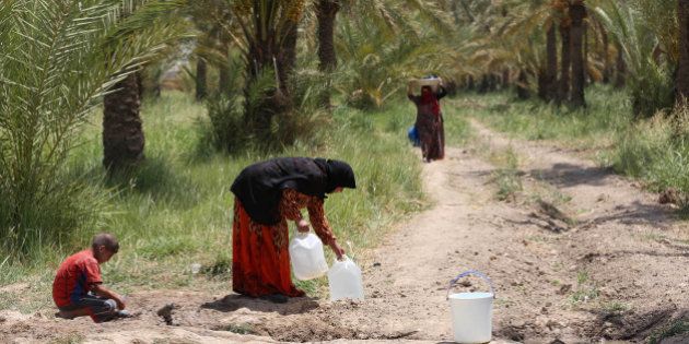 Iraqis displaced by conflict collect water at al-Takia refugee camp in Baghdad, Iraq, Thursday, July 30, 2015. Scorching temperatures are normal this time of year, but an unprecedented heat wave prompted Iraqi authorities to declare a mandatory four-day holiday beginning Thursday. The government has urged residents to stay out of the sun and drink plenty of water. (AP Photo/ Khalid Mohammed)