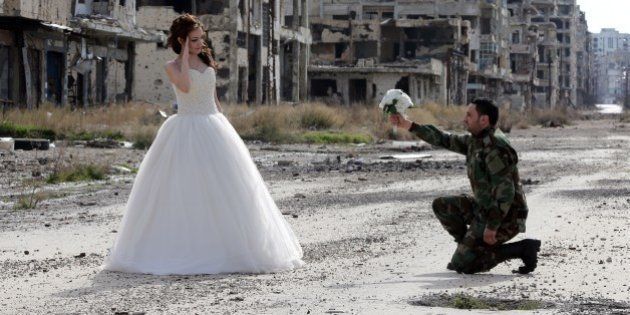 Newly-wed Syrian couple Nada Merhi,18, and Syrian army soldier Hassan Youssef,27, pose for a wedding picture amid heavily damaged buildings in the war ravaged city of Homs on February 5, 2016.A Syrian photographer thought of using the destruction of Homs to take pictures of newly wed couples to show that life is stronger than death. / AFP / JOSEPH EID (Photo credit should read JOSEPH EID/AFP/Getty Images)