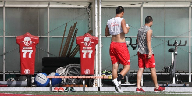 閑散とするグラウンドをランニングする日本大学アメリカンフットボール部員＝5月17日、東京都世田谷区