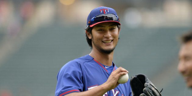 CHICAGO, IL - AUGUST 4: Starting pitcher Yu Darvish #11 of the Texas Rangers smiles as he plays catch in the outfield during batting practice before the game against the Chicago White Sox at U.S. Cellular Field on August 4, 2014 in Chicago, Illinois. (Photo by Brian Kersey/Getty Images)