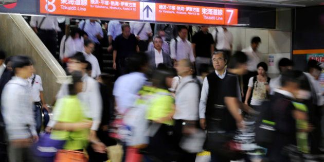 In this Friday, Sept. 12, 2014 photo, commuters walk through a train station during a morning rush hour in Tokyo. Japan's economy contracted 1.9 percent in annual terms in the July-September period, according to revised data released Monday, Dec. 8 that confirmed a recession in the world's third-largest economy ahead of an election on Sunday, Dec. 14. Data for both business and public spending were worse than anticipated. (AP Photo/Koji Sasahara)
