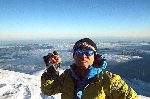 モンブランの山頂でモンブランを持つ松本圭司さん。様々な山に登り、アプリにフィードバックする。