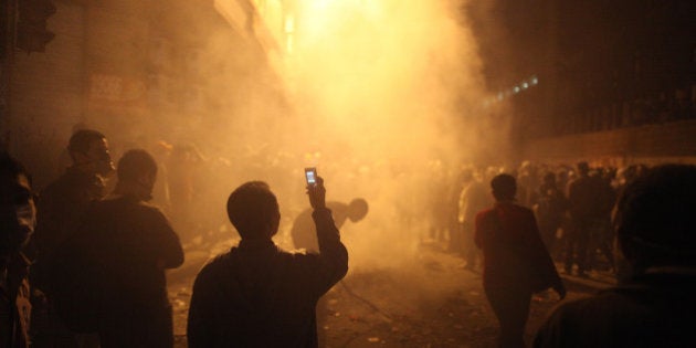 CAIRO, EGYPT - NOVEMBER 23: A youth films the aftermath of a tear gas volley fired by police on protestors in Muhammed Mahmoud Street near Tahrir Square on November 23, 2011 in Cairo, Egypt. Thousands of Egyptians are continuing to occupy Tahrir Square after four days of clashes with security forces despite a promise from military leaders to bring forward Presidential elections. (Photo by Peter Macdiarmid/Getty Images)