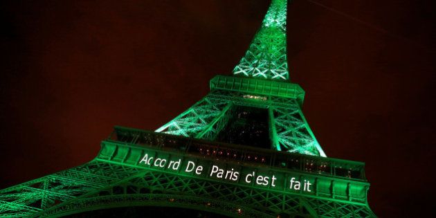 The Eiffel tower is illuminated in green with the words