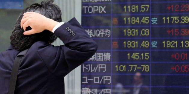 A man looks at an electronic stock board of a securities firm in Tokyo, Friday, May 23, 2014. Japan's Nikkei 225 was up 0.9 percent at 14,473.19 after the dollar climbed to near 102 yen overnight. A weaker yen is a plus for Japan's powerhouse export manufacturers. (AP Photo/Koji Sasahara)