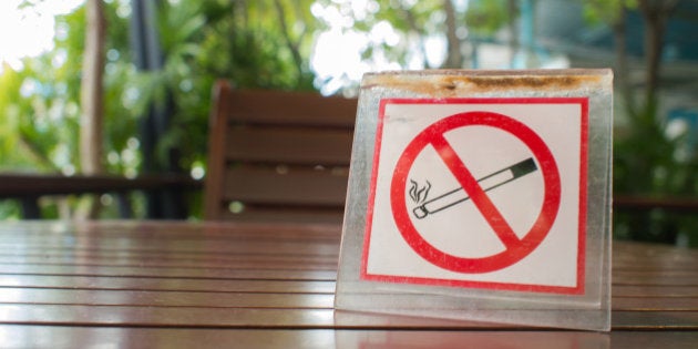 No smoking sign displayed on the wooden table in the public cafe