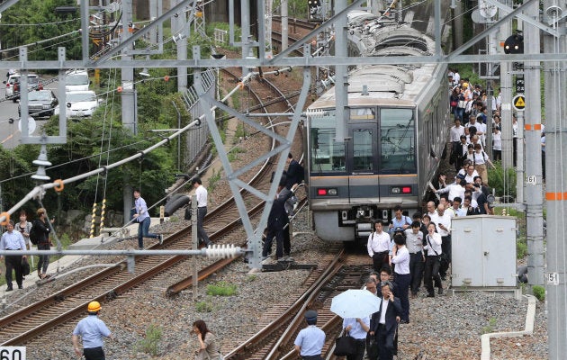 線路を歩いてＪＲ新大阪駅に向かう乗客＝１８日午前９時４分、大阪市淀川区 撮影日：2018年06月18日