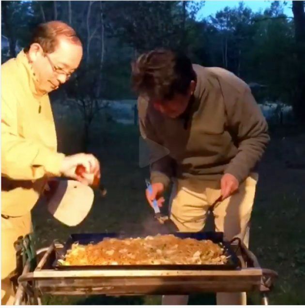 焼きそばを調理する安倍首相。左で調理を手伝う人がタバスコを入れる様子をじっと見ている。