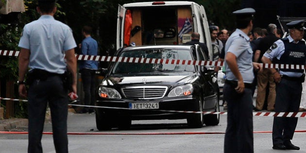 Police secure the area around the car of former Greek prime minister and former central bank chief Lucas Papademos following the detonation of an envelope injuring him and his driver, in Athens, Greece, May 25, 2017. REUTERS/Costas Baltas