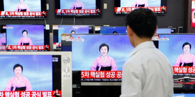 A sales assistant watches TV sets broadcasting a news report on North Korea's fifth nuclear test, in Seoul, South Korea, September 9, 2016. REUTERS/Kim Hong-Ji