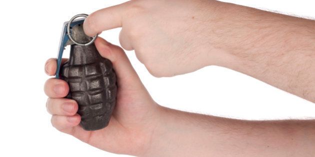 Hands holding grenade pulling the pin.Please also see: