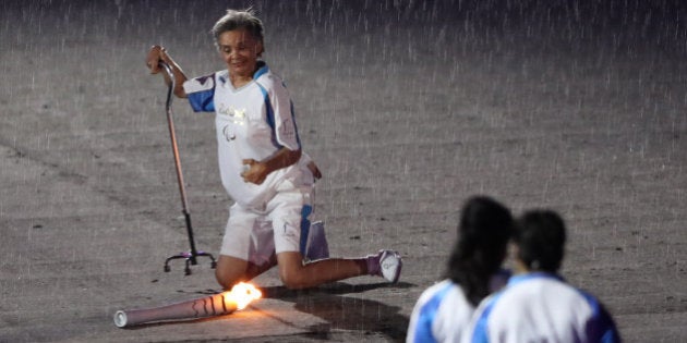 2016 Rio Paralympics - Opening ceremony - Maracana - Rio de Janeiro, Brazil - 07/09/2016. Brazilian Paralympic runner Marcia Malsar falls while carrying the torch as rain falls during the opening ceremony. REUTERS/Ueslei Marcelino FOR EDITORIAL USE ONLY. NOT FOR SALE FOR MARKETING OR ADVERTISING CAMPAIGNS.