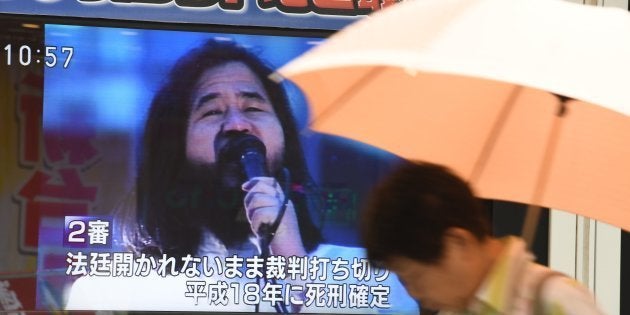 麻原彰晃死刑囚への死刑執行を伝えるTVモニターの前を通り過ぎる人（7月6日撮影）