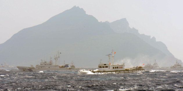 A Taiwan Coast Guard boat (R-with red flag) is blocked by a Japan Coast Guard vessel (L) in the waters near the disputed Diaoyu / Senkaku islands in the East China Sea on September 25, 2012. Coastguard vessels from Japan and Taiwan duelled with water cannon after dozens of Taiwanese boats escorted by patrol ships sailed into waters around Tokyo-controlled islands. Japanese coastguard ships sprayed water at the fishing vessels, footage on national broadcaster NHK showed, with the Taiwanese patrol boats directing their own high-pressure hoses at the Japanese ships. AFP PHOTO / Sam Yeh (Photo credit should read SAM YEH/AFP/GettyImages)
