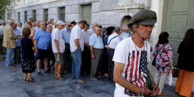 The first customers, most of them pensioners, stand in a queue to enter a branch at National Bank of Greece headquarters in Athens, Monday, July 20, 2015. Greek banks reopen on Monday morning, but many restrictions on transactions, including cash withdrawals, will remain. Also, many goods and services will become more expensive as a result of a rise in Value Added Tax approved by Parliament last Thursday, among the first batch of austerity measures demanded by Greece's creditors. (AP Photo/Thanassis Stavrakis)