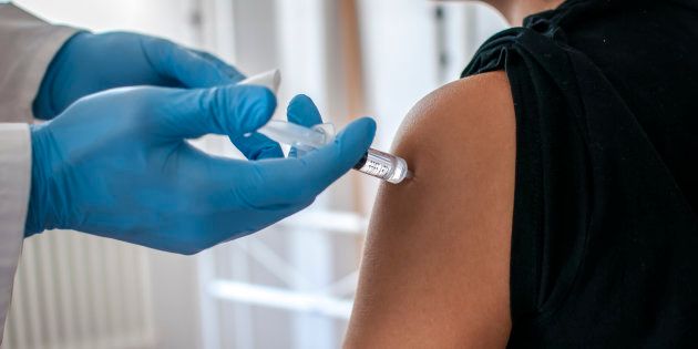 Doctor performs vaccination on a young girl