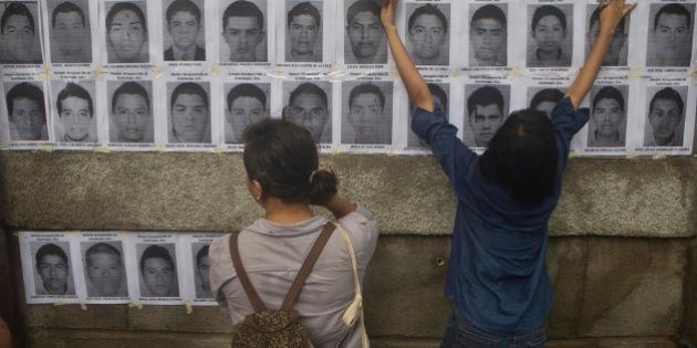 Nicaraguan demonstrators post leaflets, in protest, with the images of disappeared Mexican rural college students on the outer walls of the Mexican embassy in Managua, Nicaragua, Wednesday, Oct. 22, 2014. The Mexican government says it still does not know what happened to the young people after they were rounded up by local police in Iguala, a town in southern Mexico, and allegedly handed over to gunmen from a drug cartel Sept. 26, even though authorities have arrested 50 people allegedly involved. They include police officers and alleged members of the Guerreros Unidos cartel. (AP Photo/Esteban Felix)
