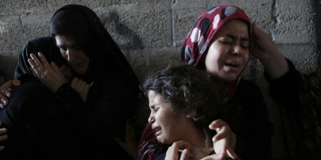 The daughters (R) of Hasan Baker, 60-years-old, grieve during his funeral in Gaza City, on July 22, 2014. A series of Israeli air strikes early killed seven people in Gaza, including five members of the same family, emergency services spokesman Ashraf al-Qudra said. The deaths hike the total Palestinian toll to 583 since the Israeli military launched Operation Protective Edge on July 8 in a bid to stamp out rocket fire from Gaza. AFP PHOTO / MOHAMMED ABED (Photo credit should read MOHAMMED ABED/AFP/Getty Images)