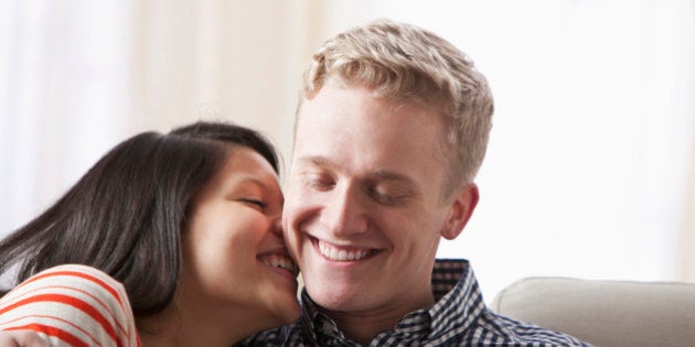 Smiling couple hugging on sofa