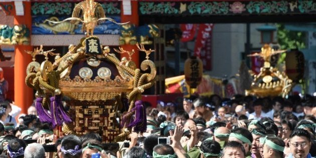 Local residents carry portable shrines into the Kanda-Myojin shrine in downtown Tokyo during the shrine's summer festival, called the Kanda Matsuri on May 10, 2015. AFP PHOTO / TOSHIFUMI KITAMURA (Photo credit should read TOSHIFUMI KITAMURA/AFP/Getty Images)