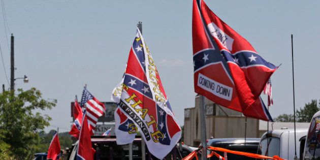 Confederate flag supporters fly their flags across the street from Durant High School, where President Barack Obama will be speaking, in Durant, Okla., Wednesday, July 15, 2015. (AP Photo/Sue Ogrocki)