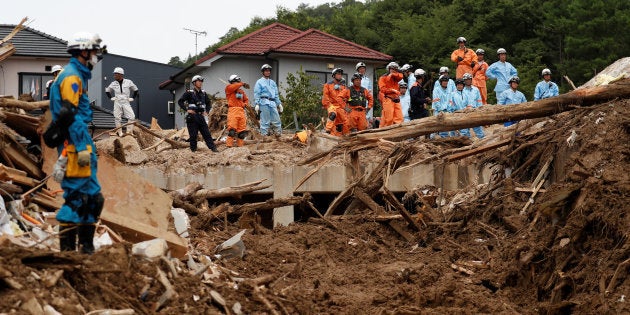 Rescue workers and Japan Self-Defense Force soldiers search for missing people at a landslide site caused by a heavy rain in Kumano Town, Hiroshima Prefecture, western Japan, July 11, 2018. REUTERS/Issei Kato