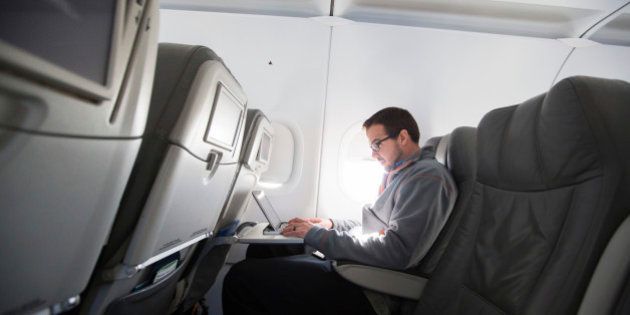 A man uses his laptop to test a new high speed inflight Internet service named Fli-Fi while on a special JetBlue media flight out of John F. Kennedy International Airport in New York December 11, 2013. Wi-Fi in the sky is taking off, promising much better connections for travelers and a bonanza for the companies that sell the systems. With satellite-based Wi-Fi, Internet speeds on jetliners are getting lightning fast. And airlines are finding that travelers expect connections in the air to rival those on the ground - and at lower cost. Picture taken December 11, 2013. To match Analysis AIRLINES-WIFI/ REUTERS/Lucas Jackson (UNITED STATES - Tags: TRANSPORT BUSINESS SCIENCE TECHNOLOGY TELECOMS TRAVEL)