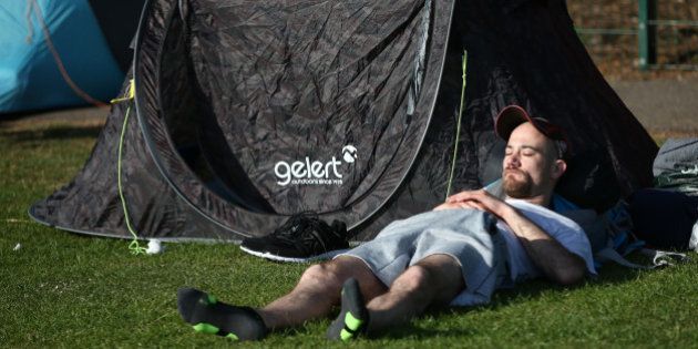 LONDON, ENGLAND - JUNE 29: A man sleeps as he queues to attend the Wimbledon tennis tournament on June 29, 2015 in London, England. The 129th tournament to be hosted at Wimbledon starts today and will run for two weeks. (Photo by Carl Court/Getty Images)