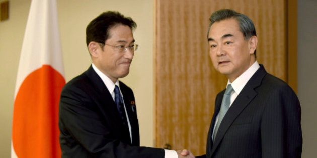 Chinese Foreign Minister Wang Yi, right, is welcomed by his Japanese counterpart Fumio Kishida prior to their bilateral meeting in Tokyo Wednesday, Aug. 24, 2016. The foreign ministers of China, Japan and South Korea criticized North Korea's latest submarine missile test on Wednesday during their annual talks that were held amid lingering frictions over territorial disputes and wartime history. (Toru Yamanaka/Pool Photo via AP)