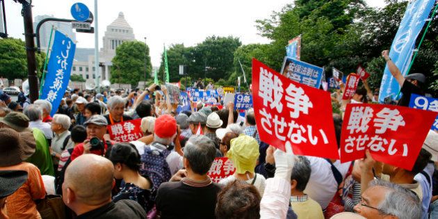 Protesters hold anti-war placards in front of the National Diet building during a rally in Tokyo, Sunday, June 14, 2015. About 25,000 protesters gathered outside the parliament, opposing a set of controversial bills intended to expand Japanâs defense role at home and internationally. (AP Photo/Shizuo Kambayashi)
