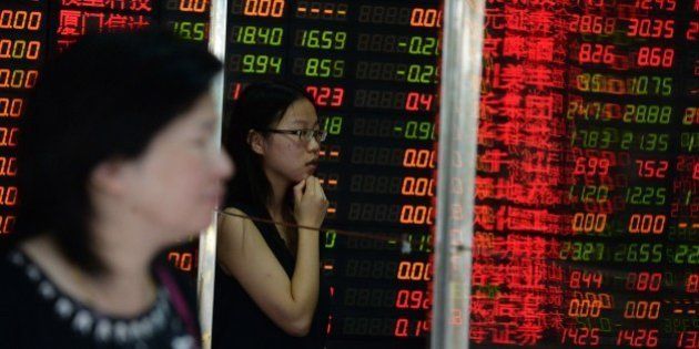 Investors check a screen displaying share prices at a security firm in Shanghai on July 6, 2015. Shanghai stocks were up 2.15 percent at midday on July 6 after the government unveiled its biggest package of measures so far to shore up the slumping market, but an initial surge was pared as analysts questioned their effect. CHINA OUT AFP PHOTO (Photo credit should read STR/AFP/Getty Images)
