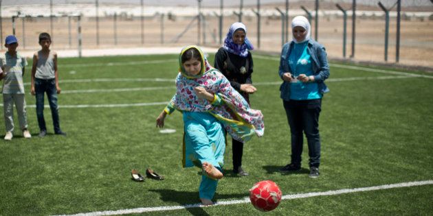 Nobel Peace Prize recipient Malala Yousafzai, 18, kicks the ball while playing soccer with Syrian refugee children during her visit to Azraq refugee camp in Jordan, Monday, July 13, 2015. Rich countries should spend less on weapons in the Syria conflict and more on education, Nobel Peace Prize winner Malala Yousafzai said Monday, calling world leaders