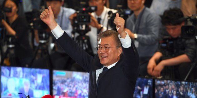 South Korean presidential candidate Moon Jae-in (C) of the Democratic Party reacts as he watches screens showing the result of exit polls of the presidential election at a hall of the National Assembly in Seoul on May 9, 2017.The projected winner of South Korea's presidential election is a former special forces soldier, pro-democracy activist and human rights lawyer. / AFP PHOTO / JUNG Yeon-Je (Photo credit should read JUNG YEON-JE/AFP/Getty Images)