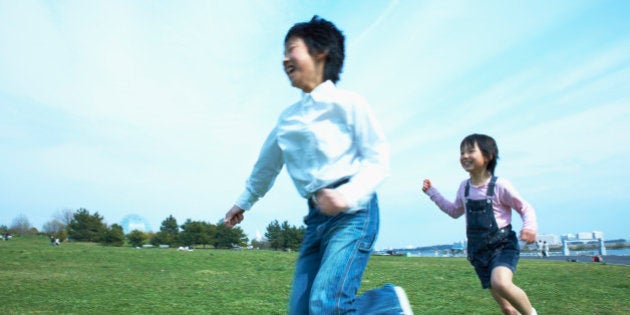 Boy and girl (8-9) running in park