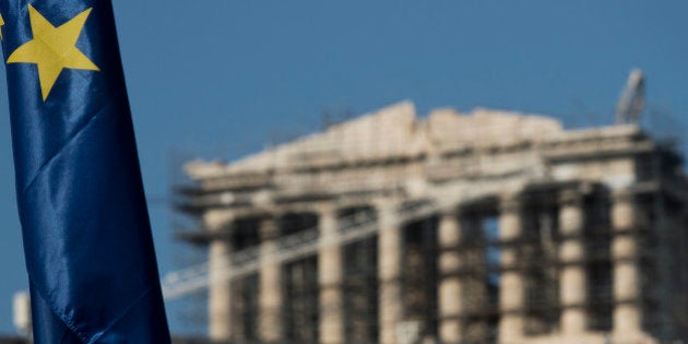 One of the stars of a European Union flag is seen in front of the ancient parthenon temple at the Acropolis hill in Athens, Monday, July 13, 2015. After grueling, often angry negotiations that tested the limits of European unity, Greece on Monday won a preliminary deal that averts financial catastrophe but also guarantees years more of hardship and sacrifice for its people. (AP Photo/Petros Giannakouris)