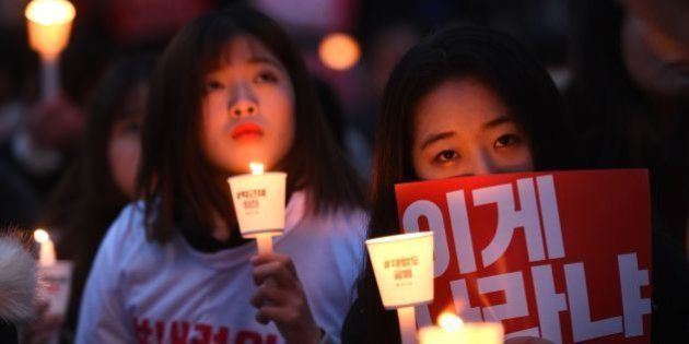 TOPSHOT - Protesters hold candles and banners calling for the resignation of South Korea's President Park Geun-Hye during an anti-government rally in central Seoul on November 19, 2016. Tens of thousands of protestors rallied in Seoul on November 19, for the fourth in a weekly series of mass protests urging President Park Geun-Hye to resign over a corruption scandal. / AFP / JUNG YEON-JE (Photo credit should read JUNG YEON-JE/AFP/Getty Images)