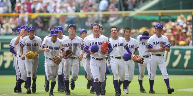 応援席にあいさつした後、笑顔を見せる吉田輝星（中央）ら金足農ナイン＝8月20日、甲子園