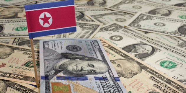 Flag of North Korea sticking in a variety of american banknotes.(series)