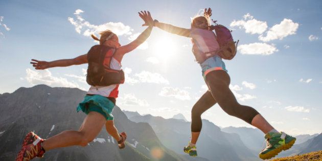 Trail runners exchange mid-air high fives, summit