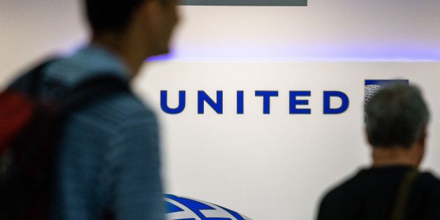 Passengers walk past signage inside the United Continental Holdings Inc. terminal at Newark Liberty International Airport (EWR) in Newark, New Jersey, U.S., on Wednesday, April 12, 2017. United Airlines is under fire for forcibly removing a passenger from a plane in Chicago shortly before departure to make room for company employees, an incident which demonstrates how airline bumping can quickly veer into confrontation. Photographer: Timothy Fadek/Bloomberg via Getty Images