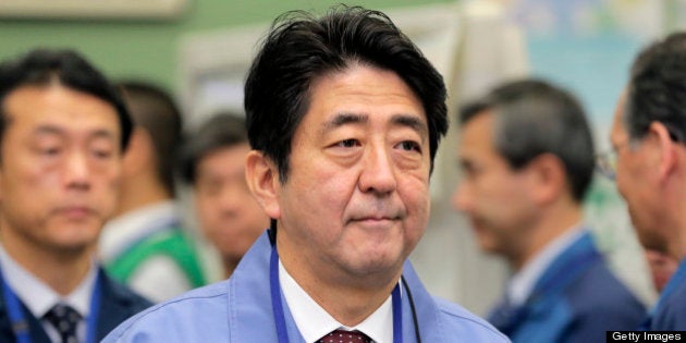 Shinzo Abe, Japan's prime minister, walks through the emergency operations center at Tokyo Electric Power...