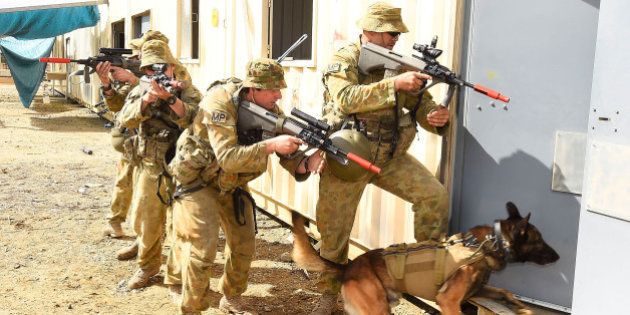 ROCKHAMPTON, AUSTRALIA - JULY 09: Australian soldiers from the 1st Military Police Battalion conduct a breach in an urban environment as part of exercise Talisman Sabre on July 9, 2015 in Rockhampton, Australia. Talisman Sabre is a biennial military exercise that trains Australian and U.S. forces to plan and conduct combined task force operations to improve combat readiness and interoperability on a variety of missions from conventional conflict to peacekeeping and humanitarian assistance efforts. TS15 will incorporate force preparation activities, Special Forces activities, amphibious landings, parachuting, land force manoeuvre, urban operations, air operations, maritime operations and the coordinated firing of live ammunition and explosive ordnance from small arms, artillery, naval vessels and aircraft. (Photo by Ian Hitchcock/Getty Images)