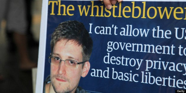 A protester holds a placard during a rally in support of Edward Snowden, the former National Security Agency contractor, in Hong Kong, China, on Saturday, June 15, 2013. Protesters marched to Hong Kongs government headquarters demanding their leaders protect Edward Snowden, who fled to the city after exposing a U.S. surveillance program. Photographer: Luke Casey/Bloomberg via Getty Images